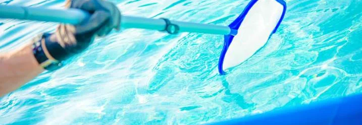 Hand reinigt Pool mit Kescher